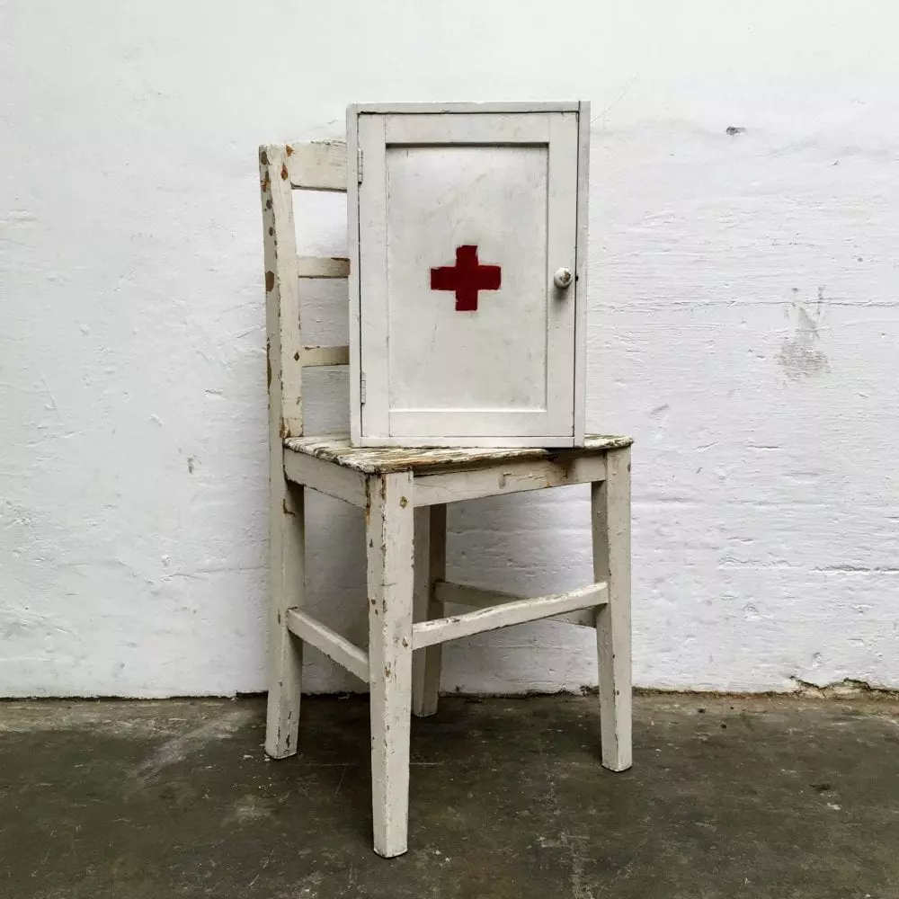 Wit houten medicijnkastje op stoel