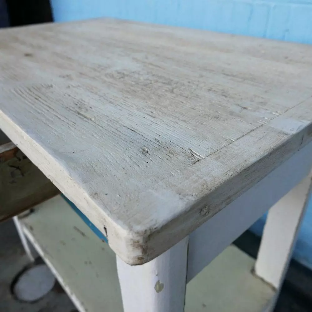 Witte houten tafel met blauwe lade en broodplank