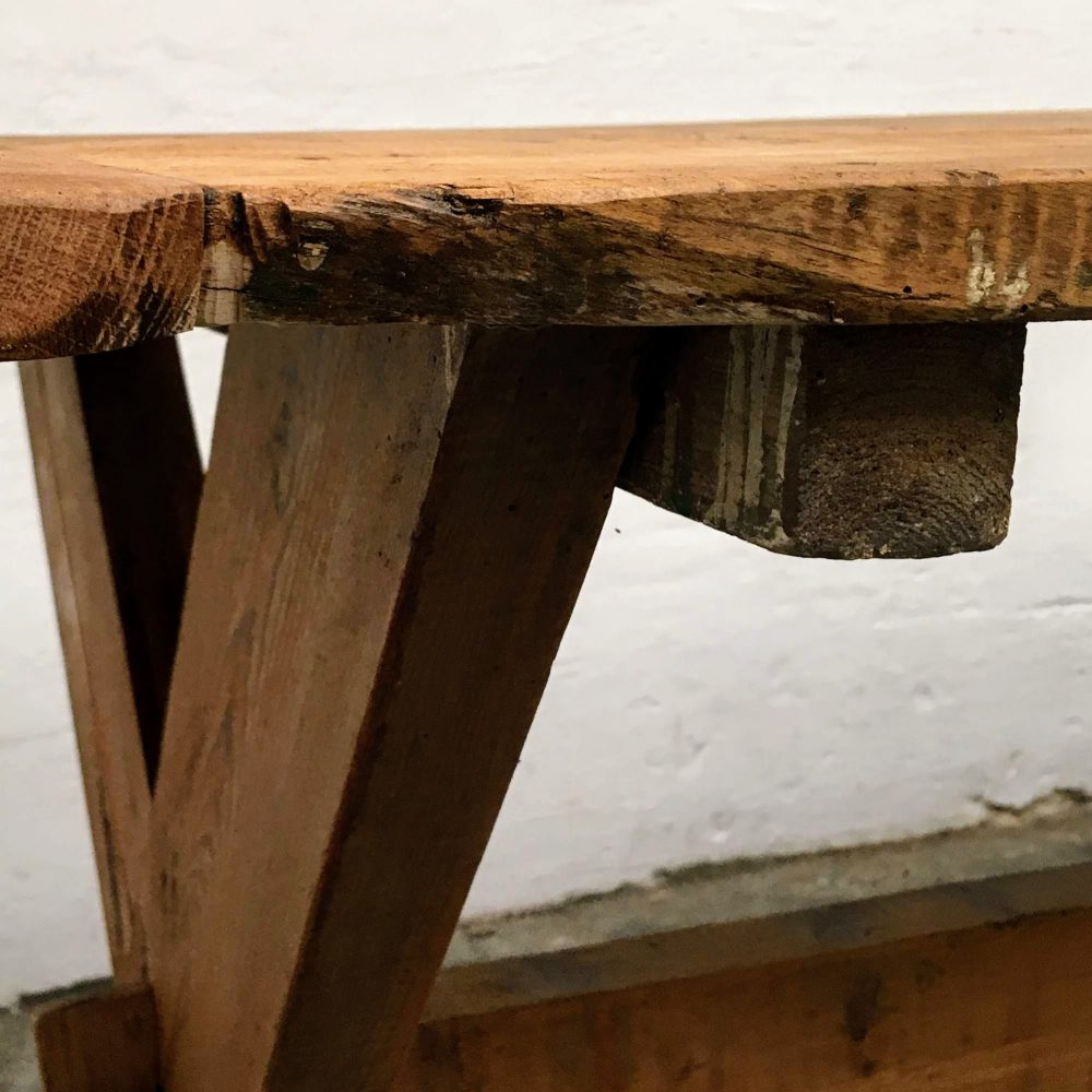 Detail van een industriële houten kruispoot tafel.