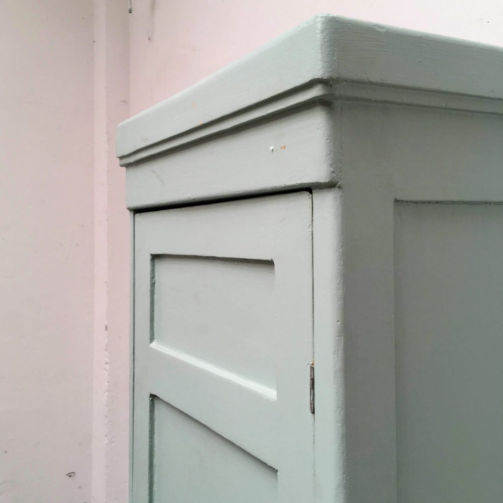 Bovenkant van blauwe houten 1-deurs kast.