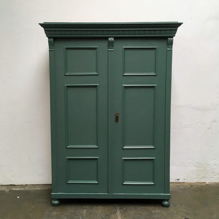 Een donkergroene houten twee deuren kast.