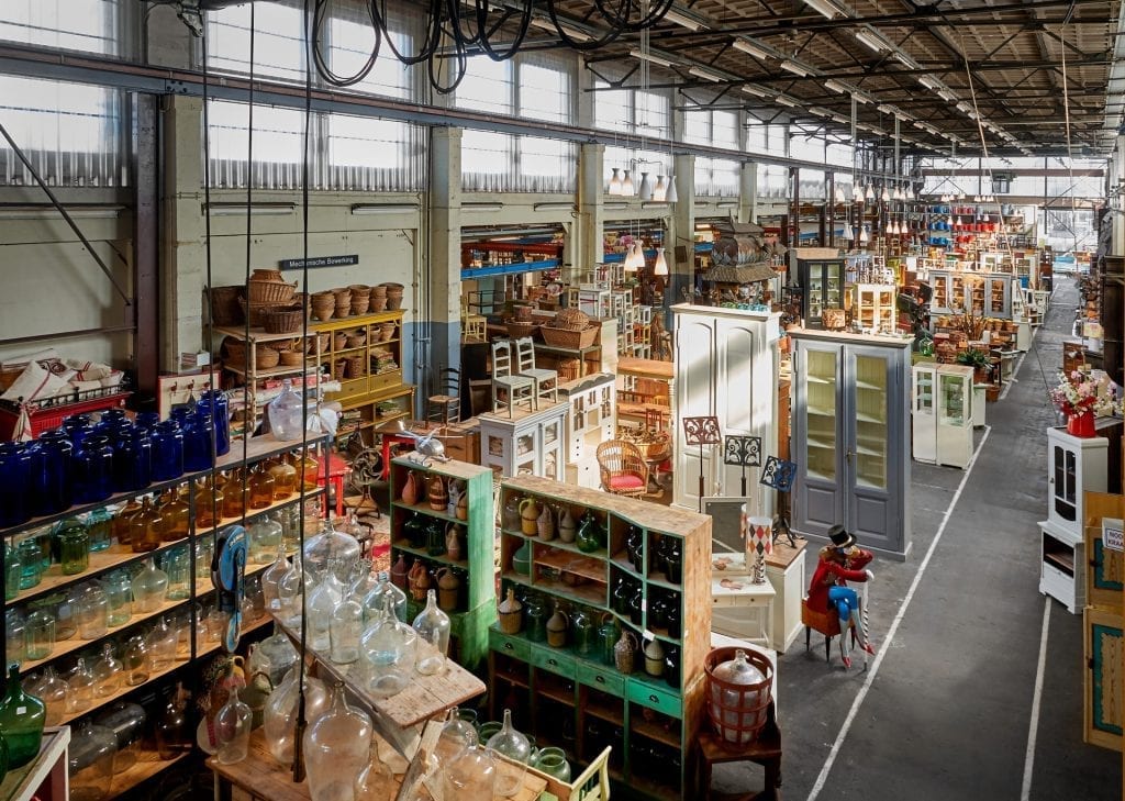 De loods Van Dijk en Ko aan de papaverweg in Amsterdam Noord vol kasten. stoelen, tafels, banken.