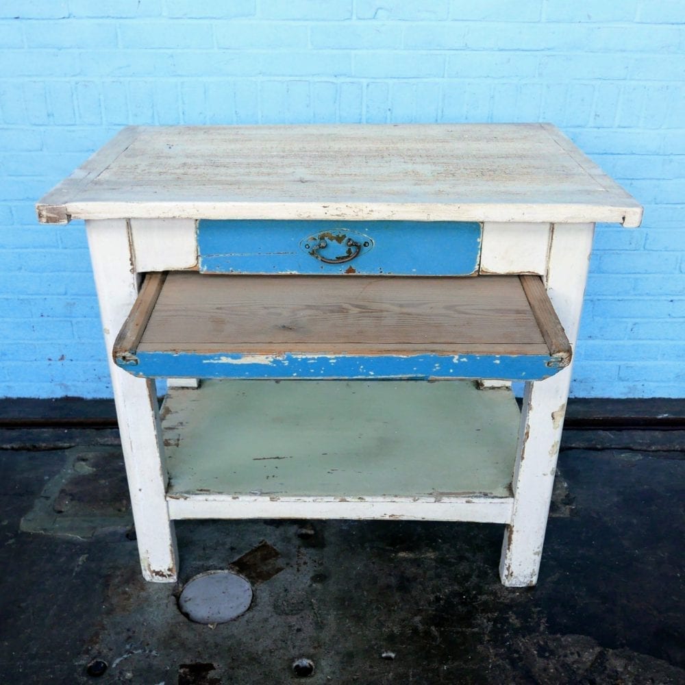 Witte houten tafel met blauwe lade en broodplank