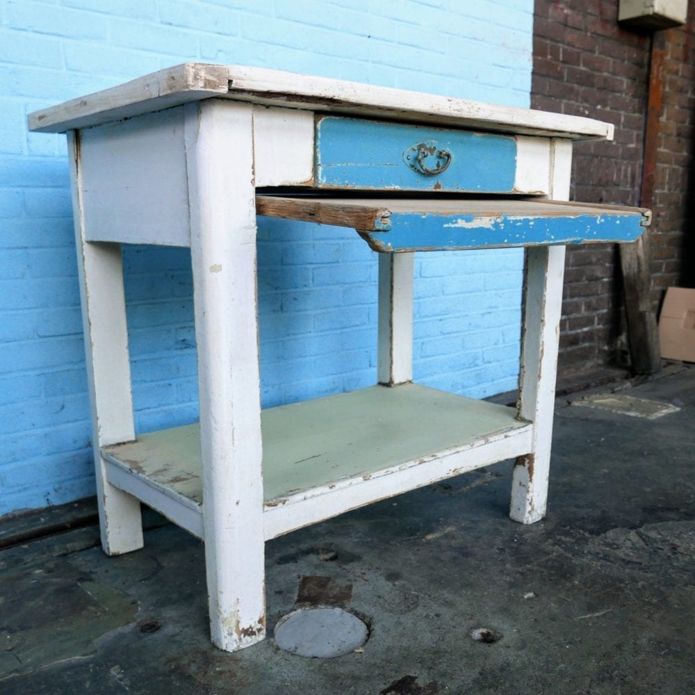 Witte houten tafel met blauwe lade en broodplank