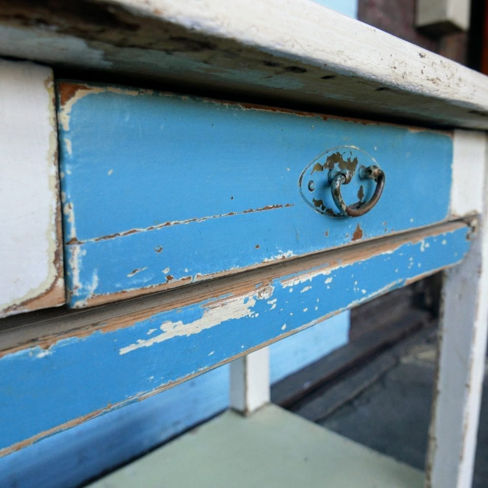Witte houten tafel met blauwe lade en broodplank